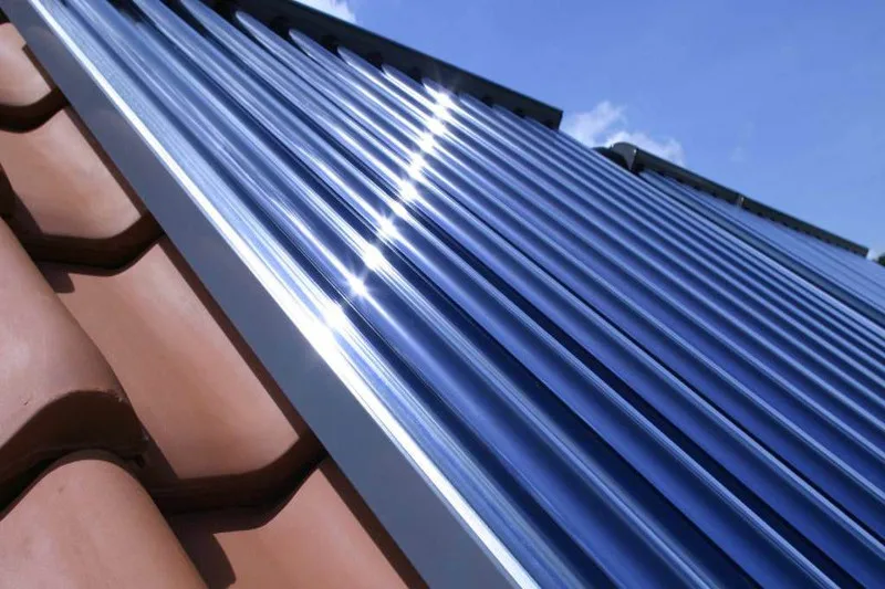 Zonnecollectoren van een zonneboiler, geplaatst op een rood pannendak.